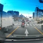 赤信号の交差点に緊急走行で侵入する白バイ