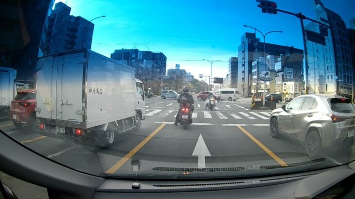 赤信号の交差点に緊急走行で侵入する白バイ